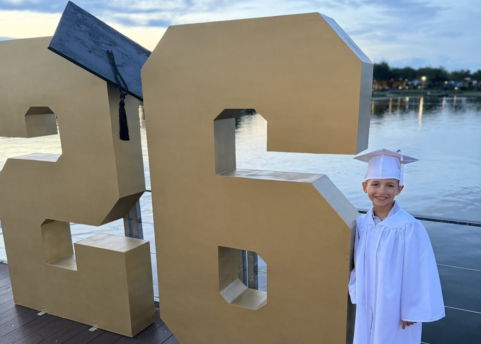 Graduates posing with the graduation number photo display at The Boardwalk Towne Lake.