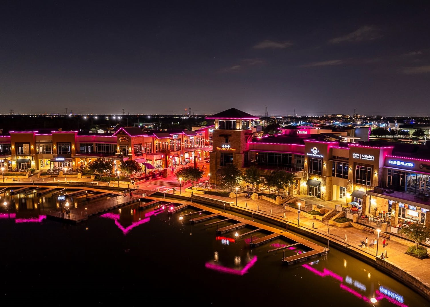 Pink lights and community members celebrating Breast Cancer Awareness Month at The Boardwalk Towne Lake.