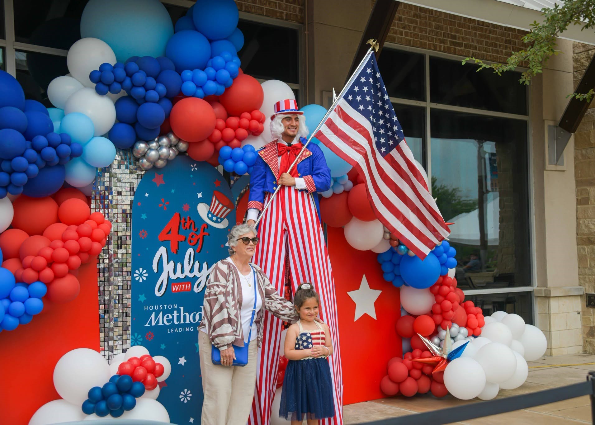 Families celebrating the Fourth of July at The Boardwalk Towne Lake in Cypress, Texas with live music and patriotic festivities.