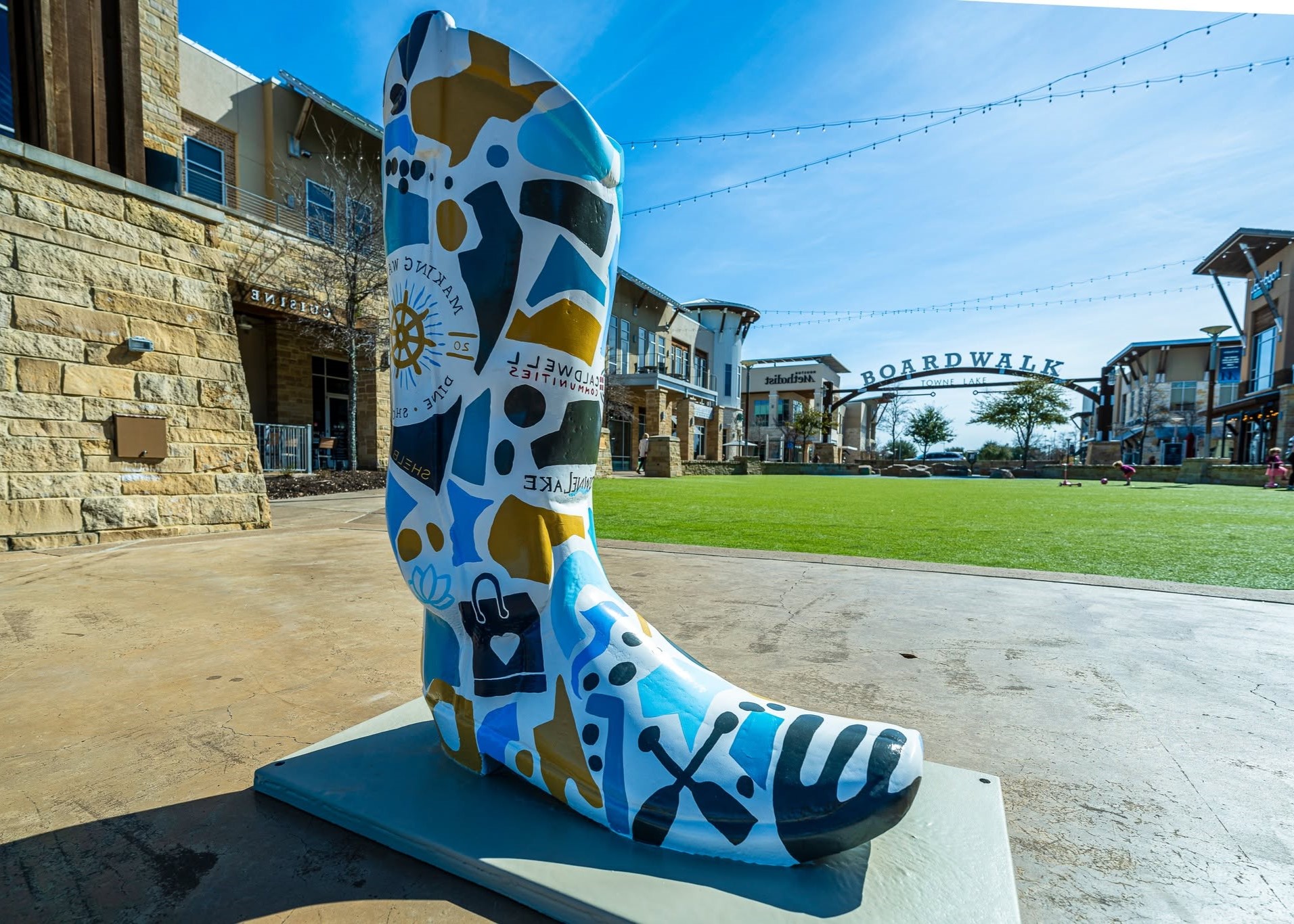 Guests posing with the oversized rodeo boot photo opportunity at The Boardwalk Towne Lake.